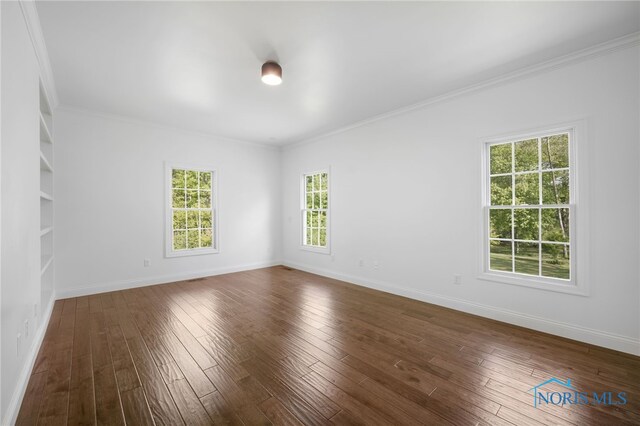 8740 Dorr St, Toledo, OH 43617 - spare room featuring dark wood-style floors, ornamental molding, and baseboards