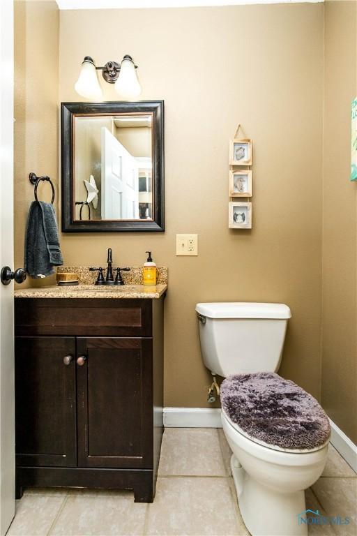 1500 S Jackson Ave, Defiance, OH 43512 - half bathroom featuring baseboards, vanity, toilet, and tile patterned flooring