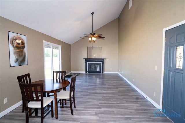 1500 S Jackson Ave, Defiance, OH 43512 - dining area featuring wood finished floors, baseboards, ceiling fan, a glass covered fireplace, and high vaulted ceiling