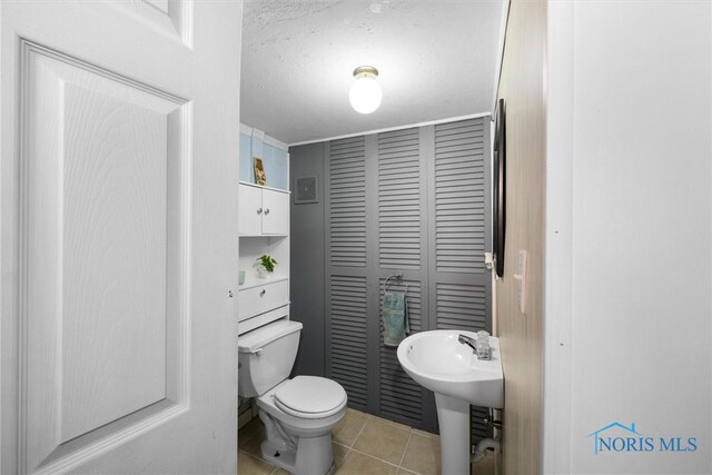 451 Toledo St, Elmore, OH 43416 - half bath featuring toilet, tile patterned floors, a closet, a textured ceiling, and a sink
