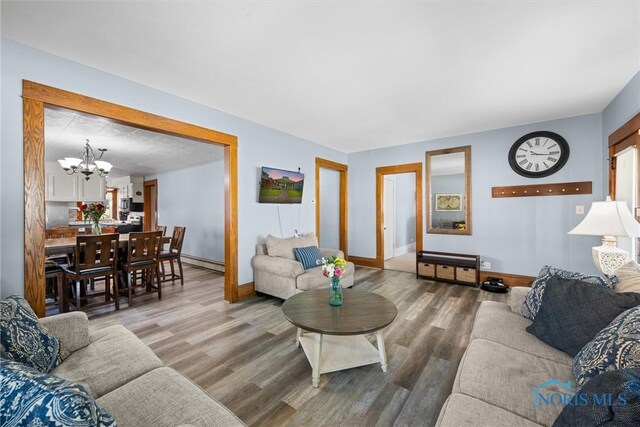 451 Toledo St, Elmore, OH 43416 - living area featuring a chandelier, a baseboard heating unit, wood finished floors, and baseboards