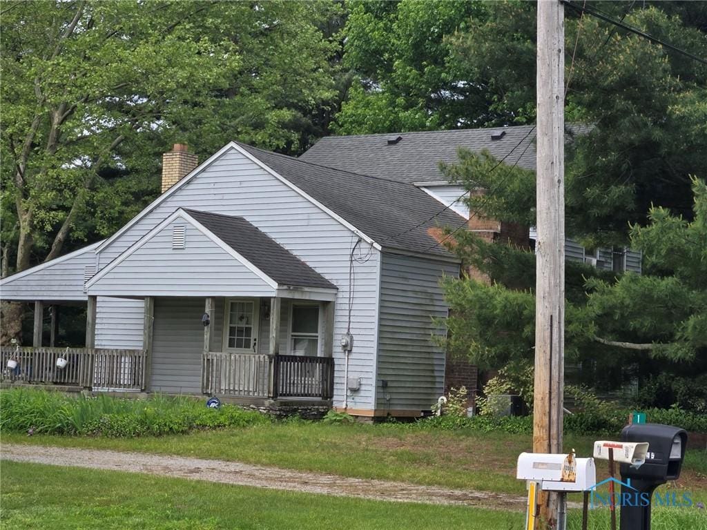 11945 Waterville Swanton Rd, Whitehouse, OH 43571 - view of front of property featuring a porch, a shingled roof, a chimney, and a front yard