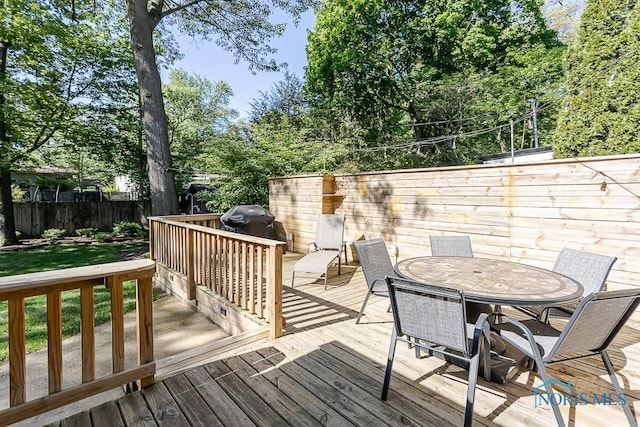 717 Birch St, Bowling Green, OH 43402 - wooden terrace with outdoor dining area, a fenced backyard, a grill, and view of scattered trees