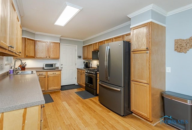 717 Birch St, Bowling Green, OH 43402 - kitchen featuring stainless steel appliances, a sink, light wood-type flooring, crown molding, and light countertops