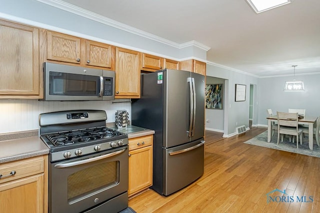 717 Birch St, Bowling Green, OH 43402 - kitchen featuring stainless steel appliances, ornamental molding, light wood-type flooring, decorative light fixtures, and baseboards