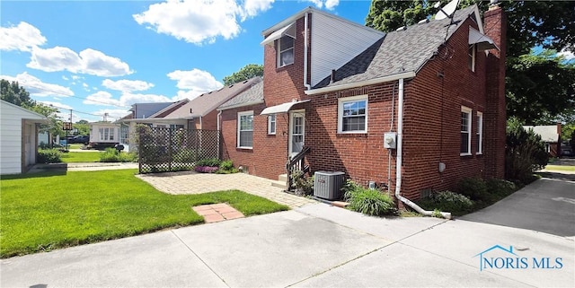 2621 Gloria Ct, Toledo, OH 43614 - view of side of home featuring brick siding, a yard, central air condition unit, and a chimney