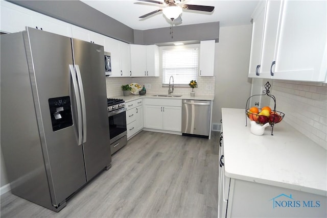 2621 Gloria Ct, Toledo, OH 43614 - kitchen with stainless steel appliances, a sink, ceiling fan, tasteful backsplash, and light wood finished floors