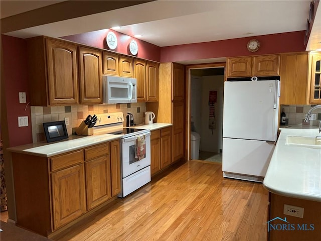 243 W S Boundary St, Perrysburg, OH 43551 - kitchen with white appliances, a sink, decorative backsplash, brown cabinets, and light countertops