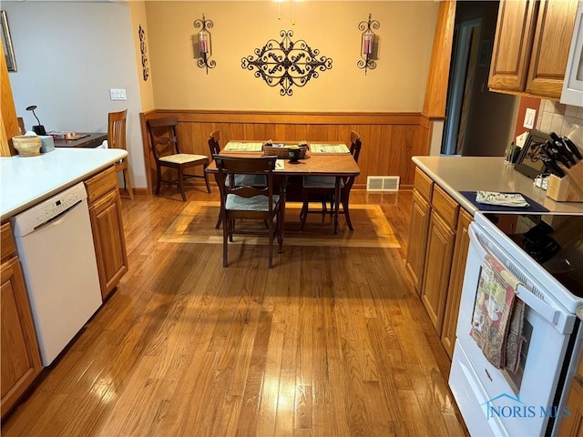 243 W S Boundary St, Perrysburg, OH 43551 - kitchen with white appliances, hardwood / wood-style flooring, wainscoting, and brown cabinetry