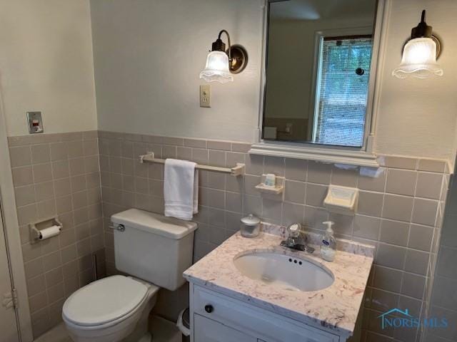 743 E Lincoln St, Findlay, OH 45840 - bathroom featuring vanity, toilet, tile walls, and wainscoting