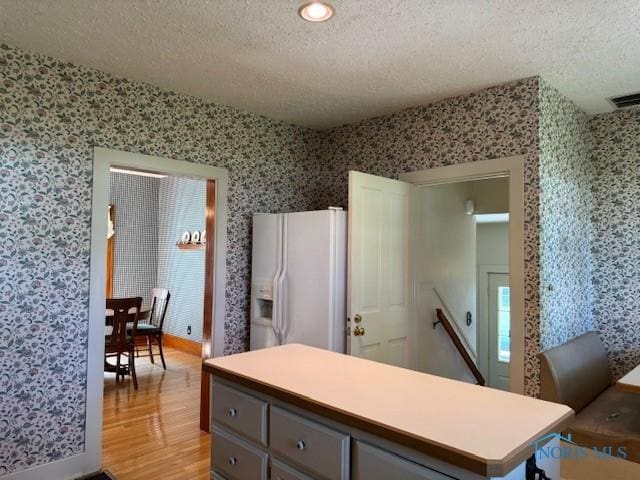 743 E Lincoln St, Findlay, OH 45840 - kitchen with white refrigerator with ice dispenser, wallpapered walls, a textured ceiling, light wood-style flooring, and gray cabinets