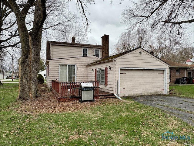 178 Gross St, Tiffin, OH 44883 - back of property featuring a chimney, asphalt driveway, an attached garage, and a lawn