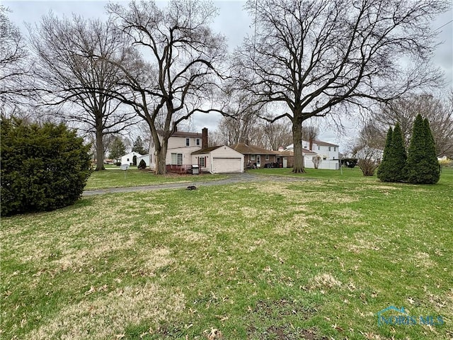 178 Gross St, Tiffin, OH 44883 - view of green lawn featuring driveway and a garage