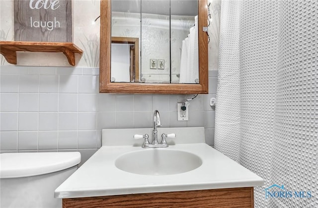 358 Burger St, Toledo, OH 43605 - bathroom with decorative backsplash, vanity, and tile walls