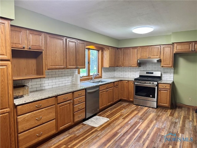 429 N Park St, Deshler, OH 43516 - kitchen featuring stainless steel appliances, under cabinet range hood, dark wood-type flooring, brown cabinetry, and tasteful backsplash