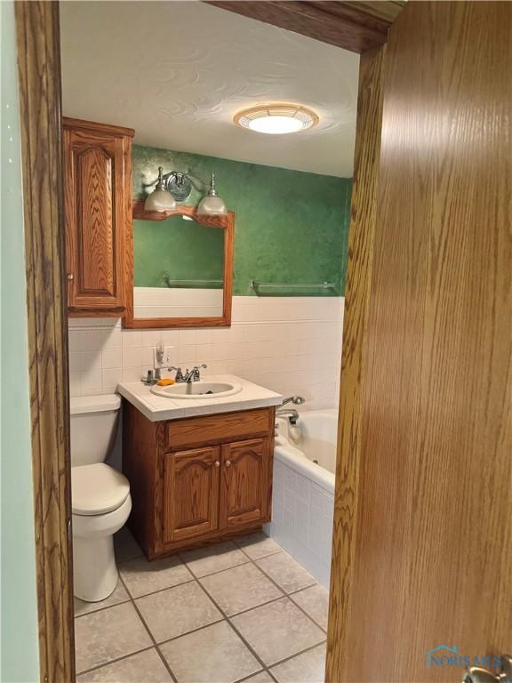 429 N Park St, Deshler, OH 43516 - bathroom with tiled tub, vanity, and tile patterned flooring