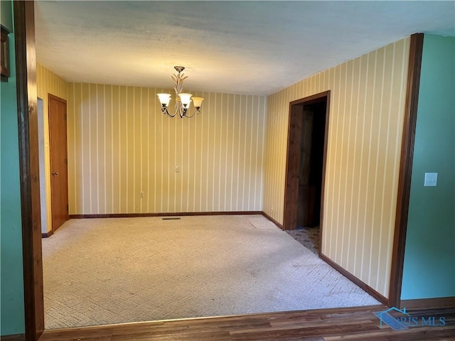 429 N Park St, Deshler, OH 43516 - empty room featuring a chandelier, wood finished floors, and carpet flooring