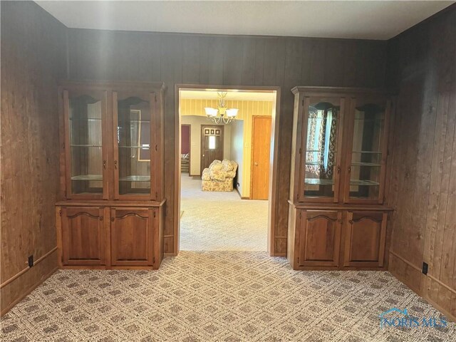 429 N Park St, Deshler, OH 43516 - dining space with a chandelier, light colored carpet, and wooden walls