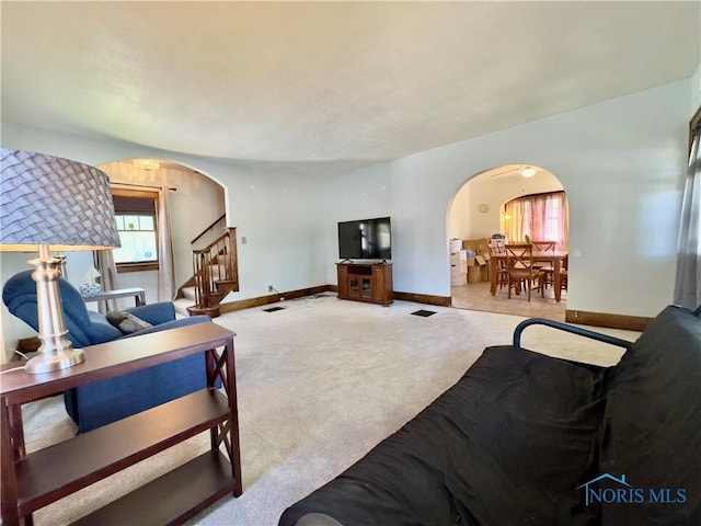 2135 Airport Hwy, Toledo, OH 43609 - carpeted living room with arched walkways, baseboards, and stairway