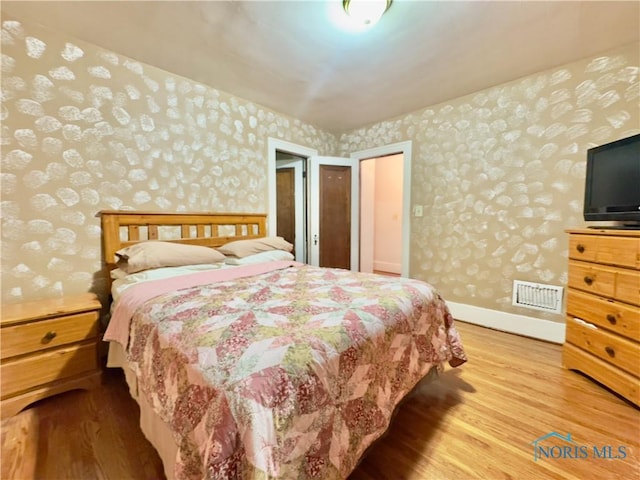 2135 Airport Hwy, Toledo, OH 43609 - bedroom with wallpapered walls, wood finished floors, and baseboards