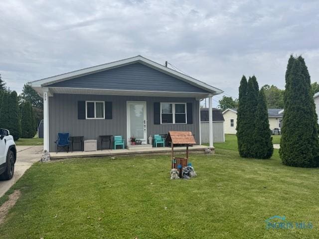 209 5th Ave, Tiffin, OH 44883 - rear view of house featuring covered porch, board and batten siding, and a lawn