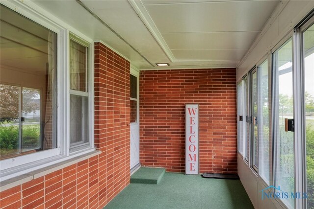 2534 Blanchard Ave, Findlay, OH 45840 - unfurnished sunroom with healthy amount of natural light, carpet floors, and brick wall