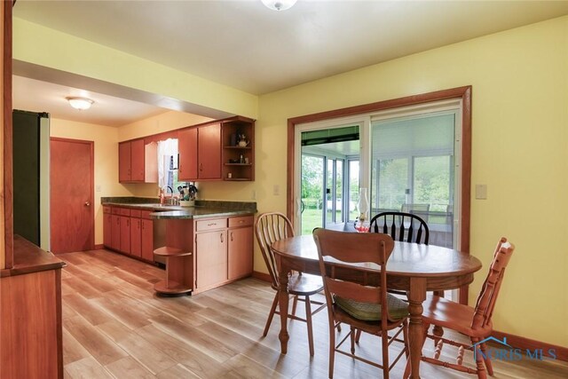 2534 Blanchard Ave, Findlay, OH 45840 - kitchen featuring dark countertops, open shelves, a sink, light wood-style floors, and baseboards