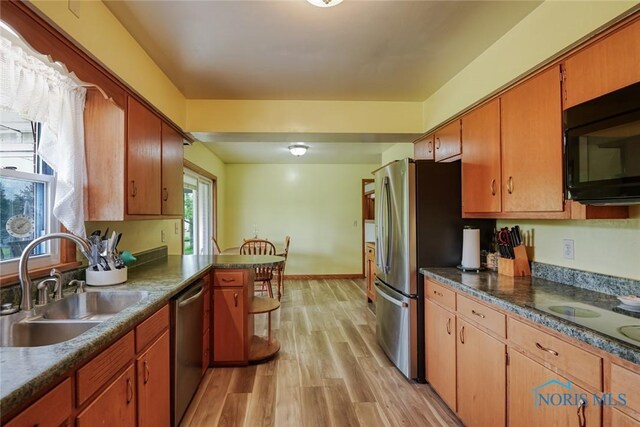 2534 Blanchard Ave, Findlay, OH 45840 - kitchen featuring a sink, stainless steel appliances, light wood finished floors, dark countertops, and a peninsula