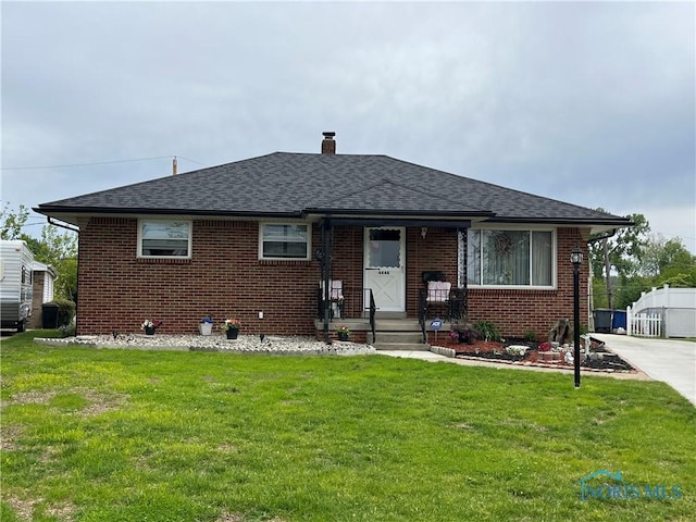 4448 Helmond Ct, Toledo, OH 43611 - bungalow-style house featuring brick siding, roof with shingles, a chimney, and a front lawn