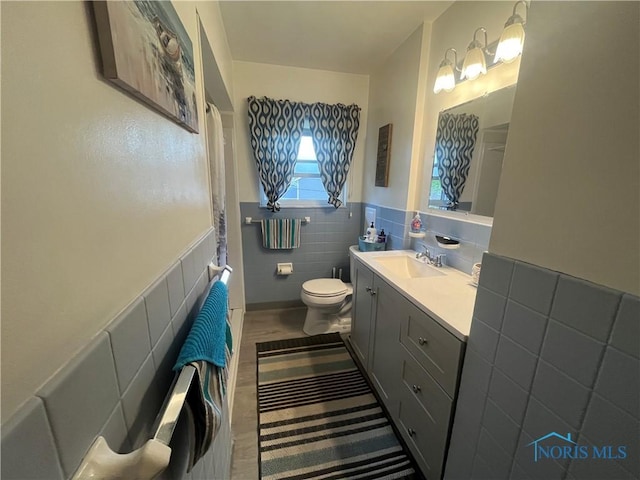 4448 Helmond Ct, Toledo, OH 43611 - full bath featuring tile walls, vanity, toilet, wainscoting, and a shower with curtain