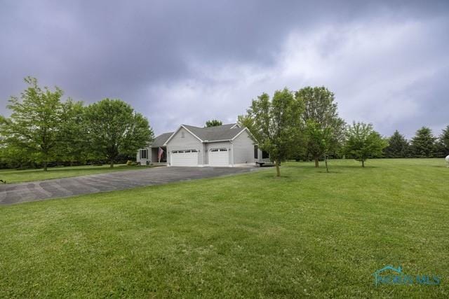 1033 Joseph Rd, Luckey, OH 43443 - view of front of house with an attached garage, asphalt driveway, and a front lawn