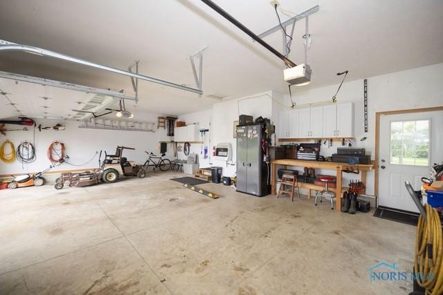 1033 Joseph Rd, Luckey, OH 43443 - garage featuring a garage door opener and freestanding refrigerator