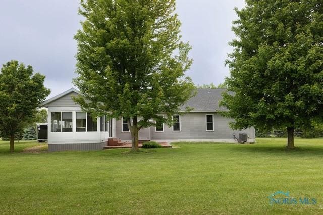 1033 Joseph Rd, Luckey, OH 43443 - back of house featuring a lawn and central air condition unit