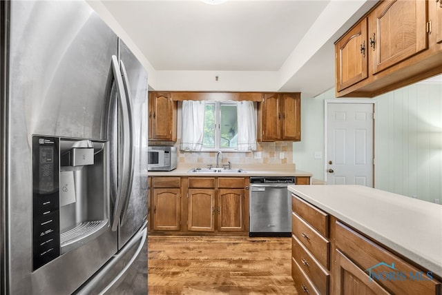 1 Hawthorne Dr, Delta, OH 43515 - kitchen with stainless steel appliances, a sink, brown cabinets, and light wood finished floors