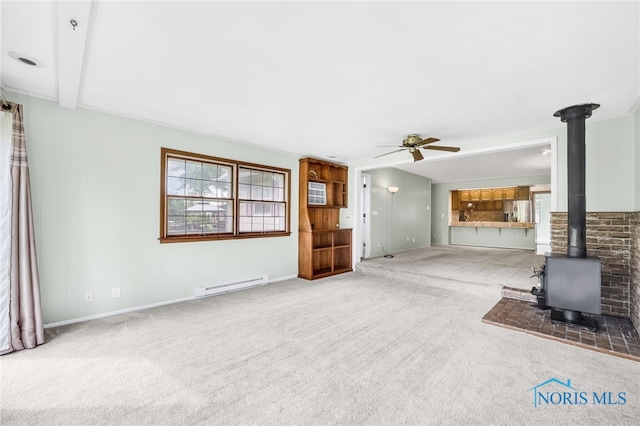 1 Hawthorne Dr, Delta, OH 43515 - unfurnished living room featuring a baseboard heating unit, a ceiling fan, a wood stove, carpet, and baseboards