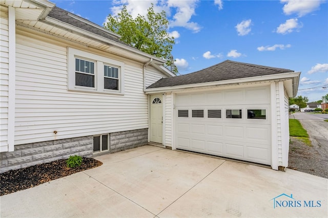 430 E 3rd St, Ottawa, OH 45875 - view of side of home with concrete driveway, a shingled roof, and an attached garage
