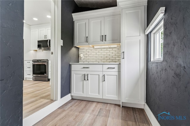 430 E 3rd St, Ottawa, OH 45875 - kitchen with appliances with stainless steel finishes, light wood finished floors, white cabinetry, light countertops, and baseboards