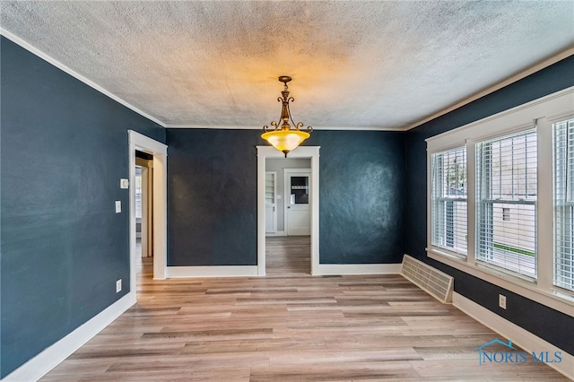 430 E 3rd St, Ottawa, OH 45875 - unfurnished dining area featuring wood finished floors, a textured ceiling, ornamental molding, baseboards, and a chandelier