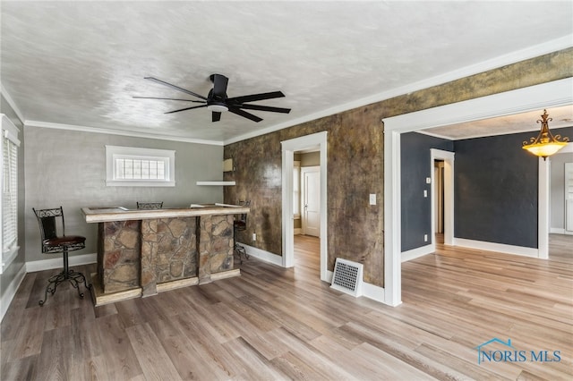 430 E 3rd St, Ottawa, OH 45875 - unfurnished living room featuring baseboards, wood finished floors, a ceiling fan, and crown molding