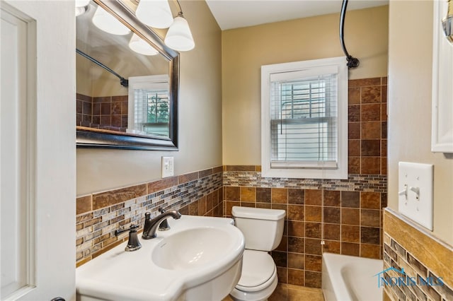 430 E 3rd St, Ottawa, OH 45875 - bathroom featuring tile walls, toilet, shower / washtub combination, wainscoting, and a sink