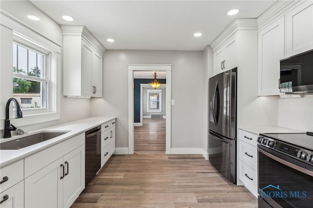 430 E 3rd St, Ottawa, OH 45875 - kitchen featuring stainless steel appliances, a sink, white cabinetry, light wood-style floors, and light countertops