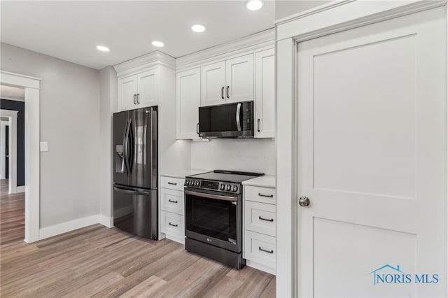 430 E 3rd St, Ottawa, OH 45875 - kitchen with appliances with stainless steel finishes, white cabinets, light wood-style flooring, light countertops, and recessed lighting