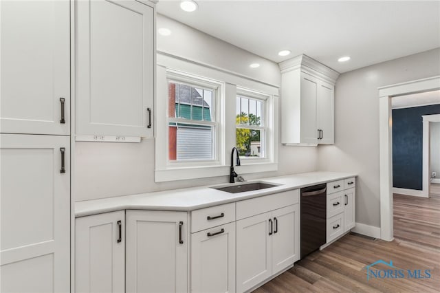 430 E 3rd St, Ottawa, OH 45875 - kitchen with dishwasher, a sink, white cabinets, wood finished floors, and light countertops