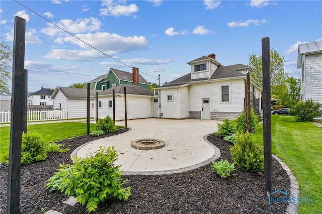 430 E 3rd St, Ottawa, OH 45875 - rear view of house with an outdoor structure, a patio area, curved driveway, a fire pit, and a chimney