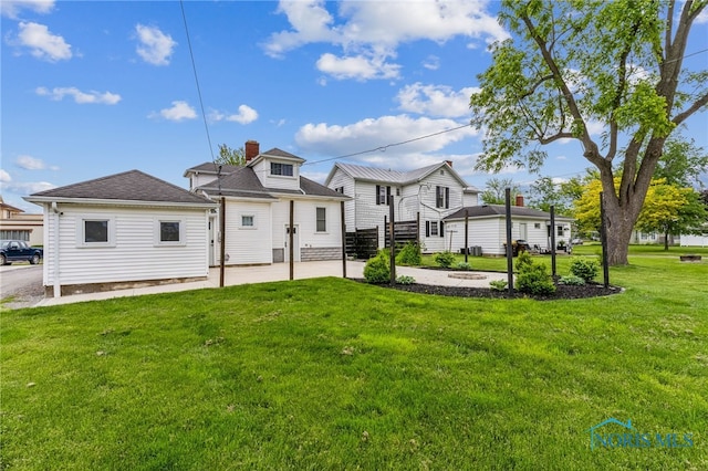 430 E 3rd St, Ottawa, OH 45875 - back of house with a yard, a patio area, and a chimney