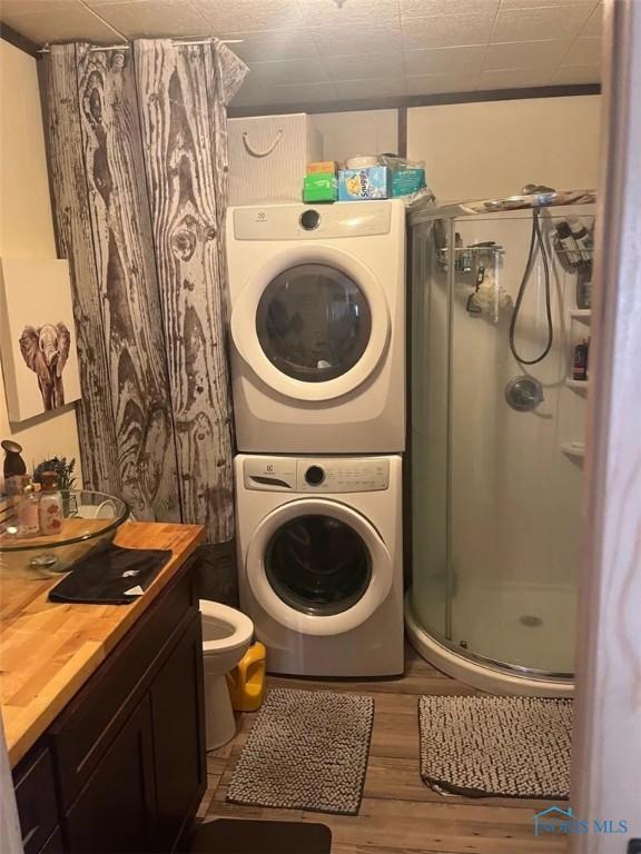 201 W Wabash St, Liberty Center, OH 43532 - washroom with stacked washer and clothes dryer and wood finished floors
