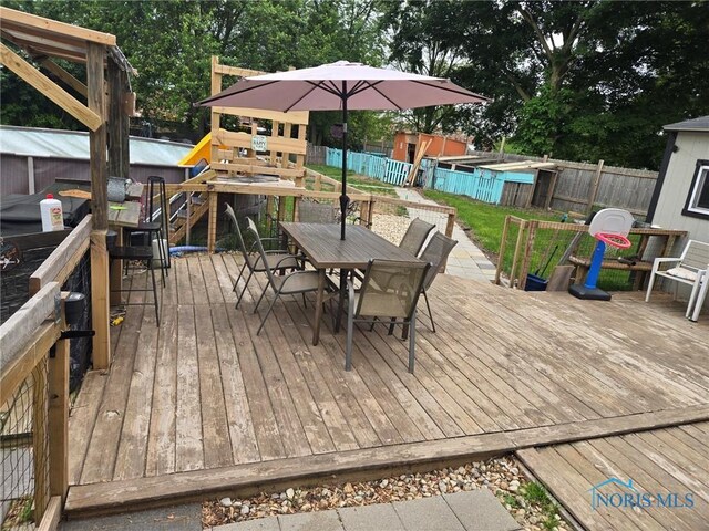 201 W Wabash St, Liberty Center, OH 43532 - wooden terrace with outdoor dining area, a storage shed, a playground, and a fenced backyard