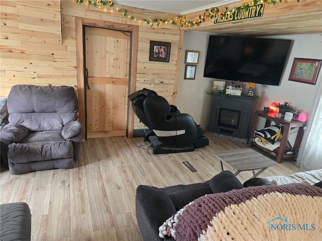 201 W Wabash St, Liberty Center, OH 43532 - living area with wood walls, a glass covered fireplace, wood finished floors, and crown molding