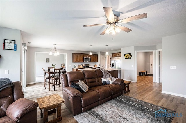 116 Wirth Ln, Sherwood, OH 43556 - living area with light wood-style floors, a ceiling fan, baseboards, and a chandelier