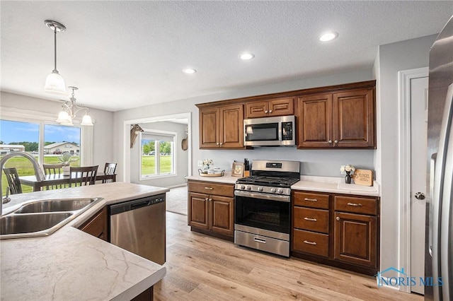 116 Wirth Ln, Sherwood, OH 43556 - kitchen with appliances with stainless steel finishes, a sink, light countertops, decorative light fixtures, and light wood finished floors